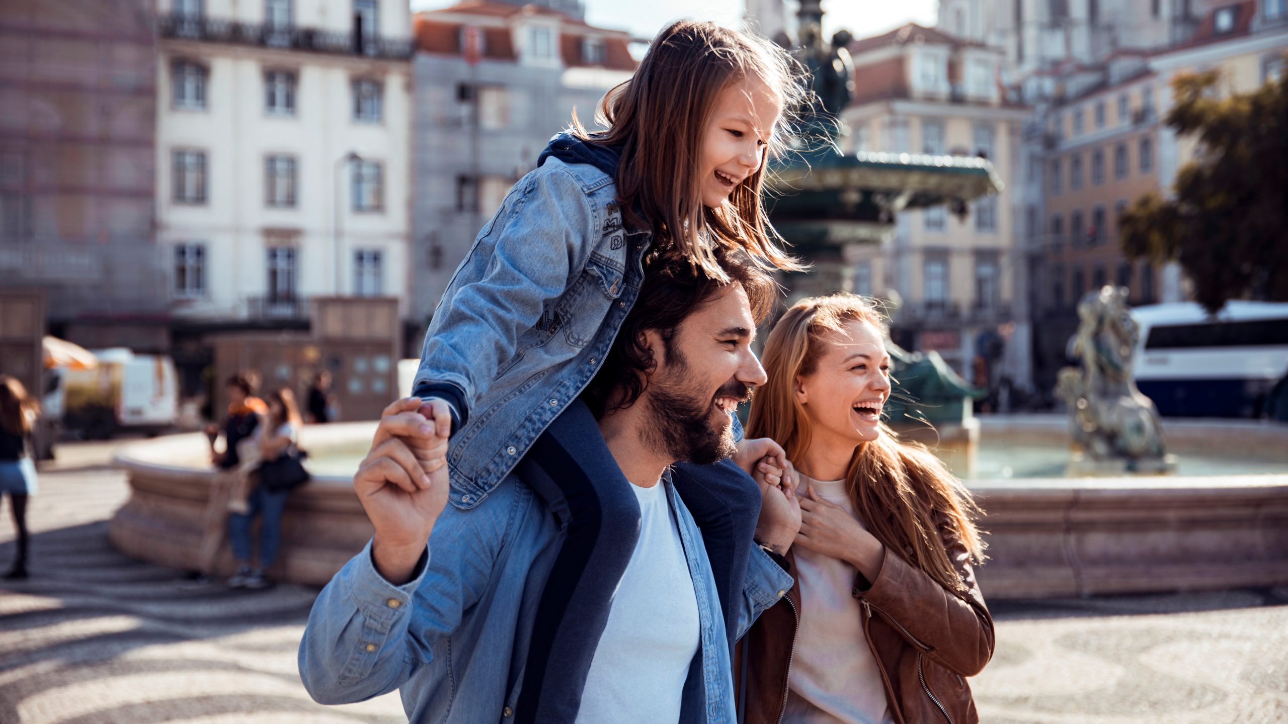 Close up of a young happy family exploring a European city.