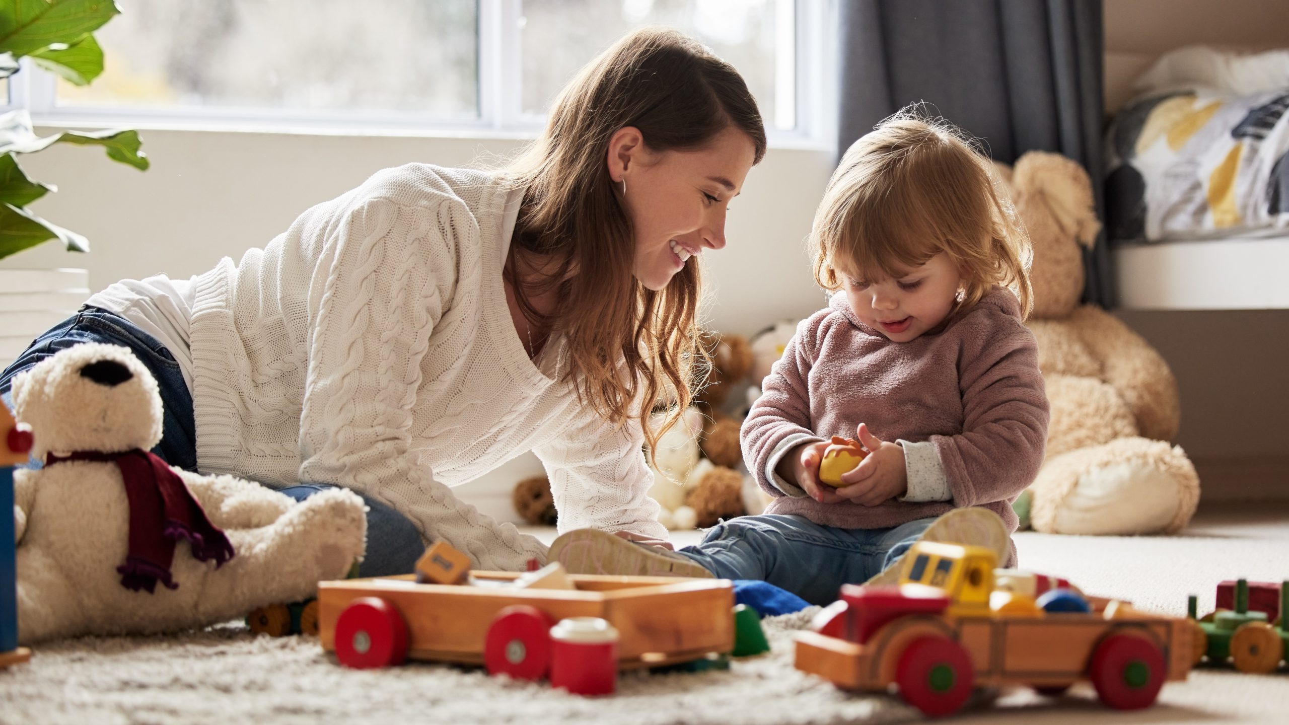 An image of a young mother and daughter playing at home.