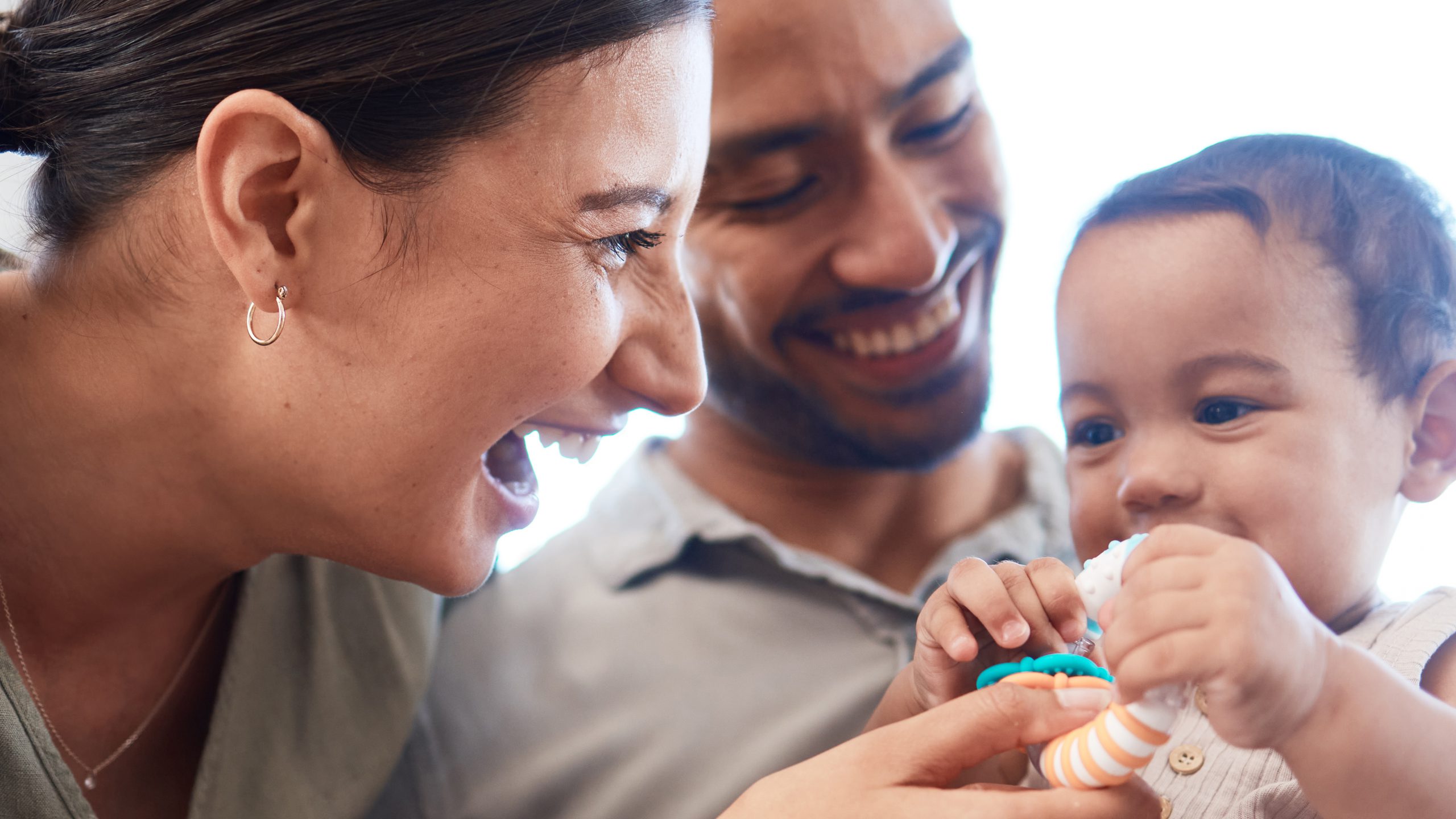 A young couple bonding with their baby girl on a sofa at home