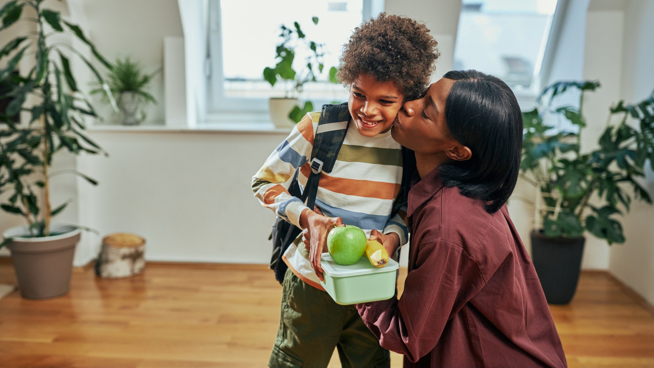 Child being kissed goodbye before going to school