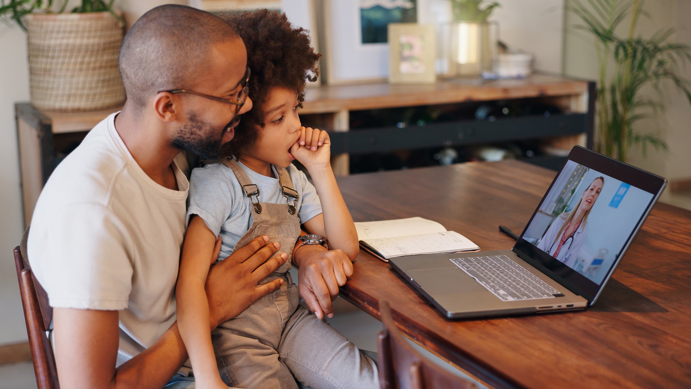 Father and daughter using video visit to speak to clinician