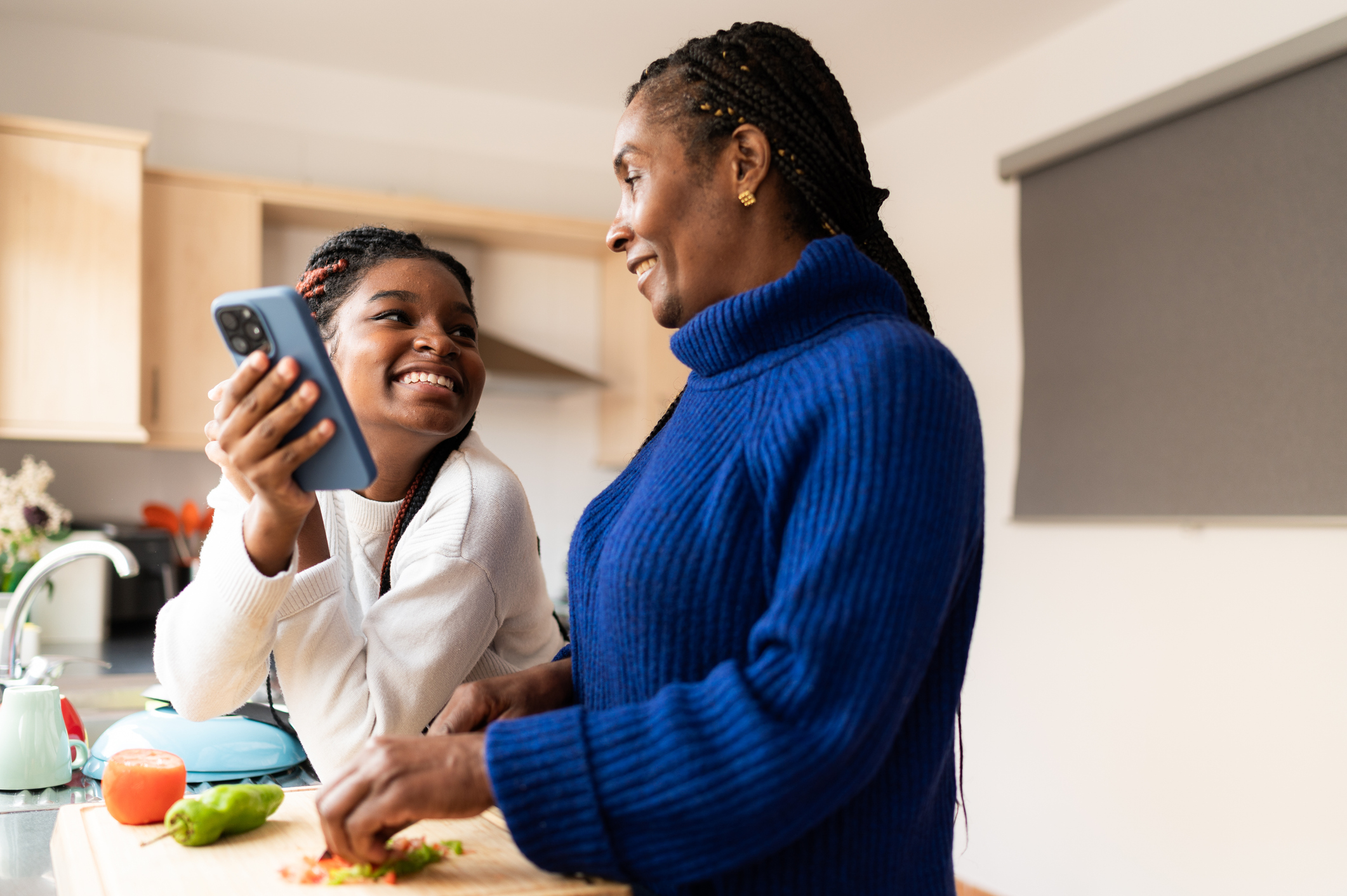 Mother and daughter sharing a moment while cooking in the kitchen Mother and daughter